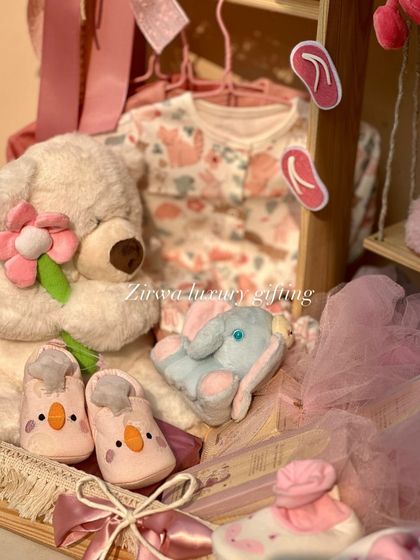 Pretty in pink. This hamper is filled with a floral onesie, a cuddly teddy bear, an elephant plushie, and tiny shoes, all carefully arranged in a keepsake wardrobe.