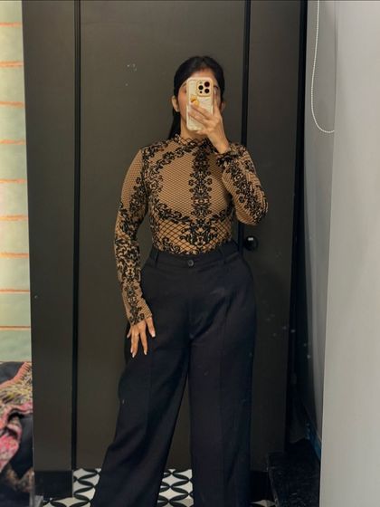 A sheer printed top paired with wide-leg trousers. This is a chic and modern office look that can easily transition to an evening out.