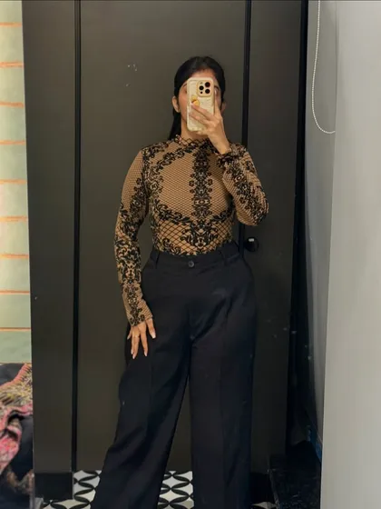 A sheer printed top paired with wide-leg trousers. This is a chic and modern office look that can easily transition to an evening out.