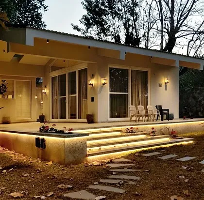 Another view of the Amberle farmhouse, where the illuminated steps create a floating effect over the lawn. This design detail adds a touch of modern elegance to the rustic setting.