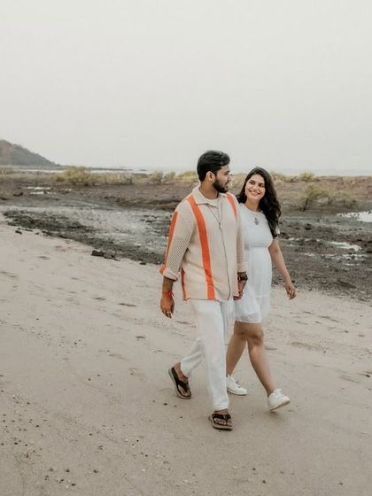 The couple enjoys a walk along a quiet, less-traveled part of the beach. This shot captures a sense of adventure and shared exploration.