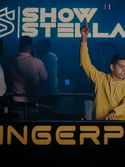 One hand up for the crowd at Fingerprint, with the VJ screen creating a powerful backdrop.