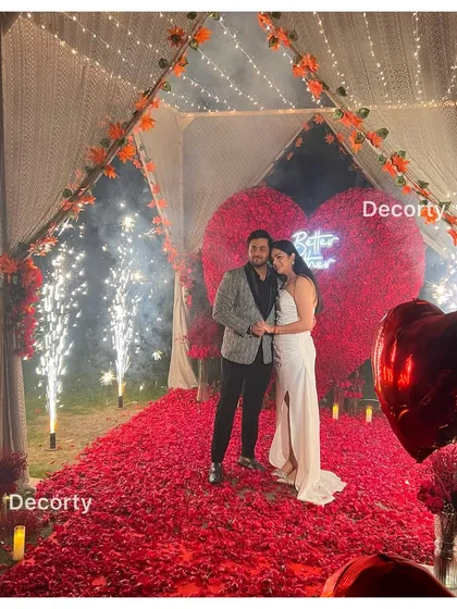 The happy couple celebrating their engagement with cold pyro fireworks, surrounded by a sea of red roses. I can arrange for special effects to add extra sparkle to your big moment.