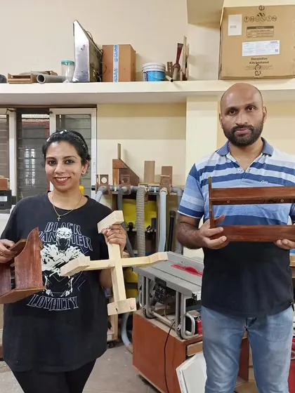 Roshni and Wilson with their first day's projects. They've built a planter stand and a small side table, mastering the basics of power tool usage.