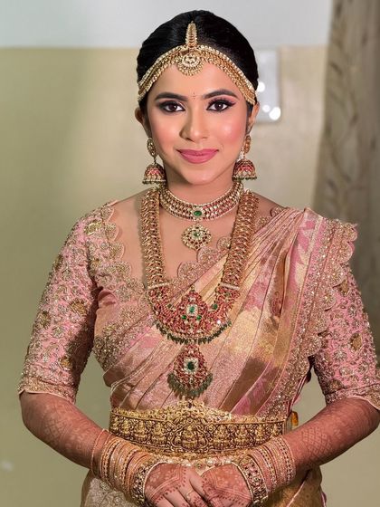 The bride's look without the veil, showcasing her beautiful hair and the intricate details of her jewelry and blouse.