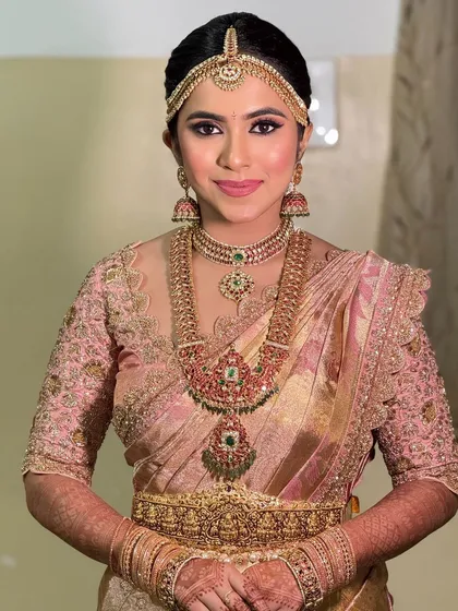The bride's look without the veil, showcasing her beautiful hair and the intricate details of her jewelry and blouse.
