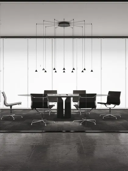 A large, spider-like configuration of the Filomena system, providing focused light over a long conference table. This is a perfect example of a highly functional and aesthetically minimal lighting solution for corporate spaces.