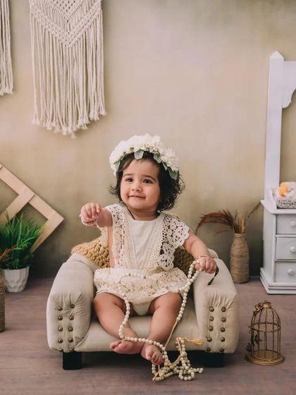 This little girl is playing with a string of pearls, a sweet and candid moment from her boho-themed sitter session.