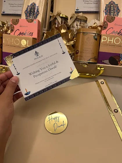 A personalized greeting card for Priyablue Shipping, placed elegantly on top of their custom Diwali trunk hamper.