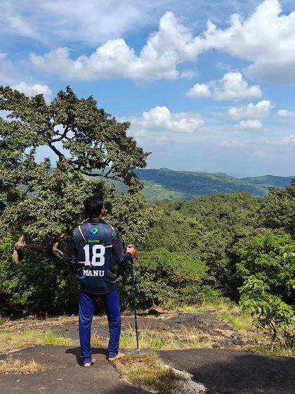 A trekker looking out at the endless green canopy of the Agumbe forest.