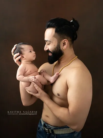 A new dad holds his daughter, their eyes meeting in a moment of pure connection. This portrait beautifully captures the beginning of their lifelong bond.