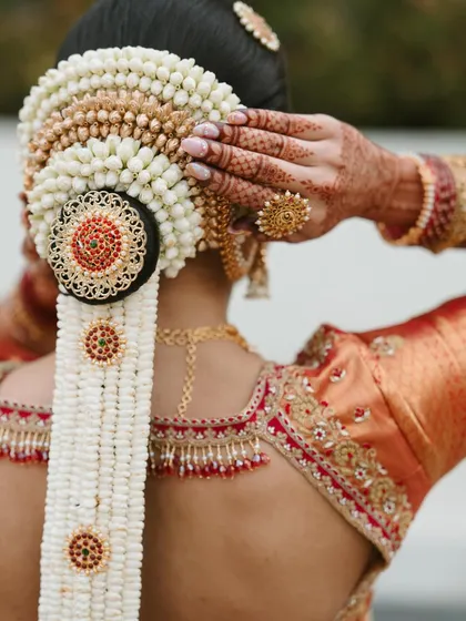 The details complete the story. I love creating traditional South Indian bridal hairstyles, from intricate braids to stunning floral arrangements like this classic jasmine and gold jada, which perfectly complements the bridal saree and jewellery.