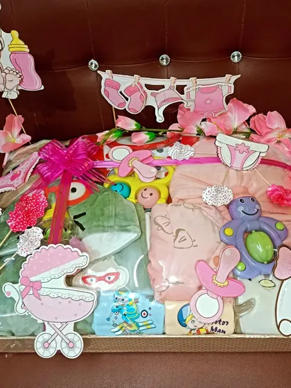 Another view of the pink-themed baby girl hamper, showcasing the arrangement of clothes and toys.