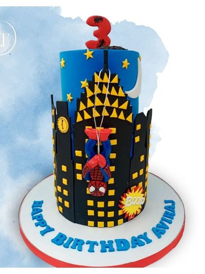 A dynamic two-tiered Spider-Man cake, showing the hero hanging upside down from the city skyline.