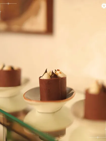 Miniature chocolate dessert cups, each one a perfect bite of indulgence. These are ideal for intimate gatherings where detail and quality are paramount.