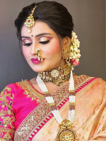 A beautiful Maharashtrian bridal look with a traditional nath and chandrakor bindi. The eye makeup is a soft pink, complementing the Paithani saree.
