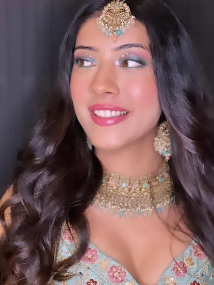 A beautiful and bright party look. The makeup features a pop of green and blue on the eyes, paired with a glossy pink lip for a fun and vibrant style.