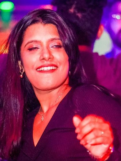 A guest enjoying the music with a friend, the colorful lights adding to the atmosphere.