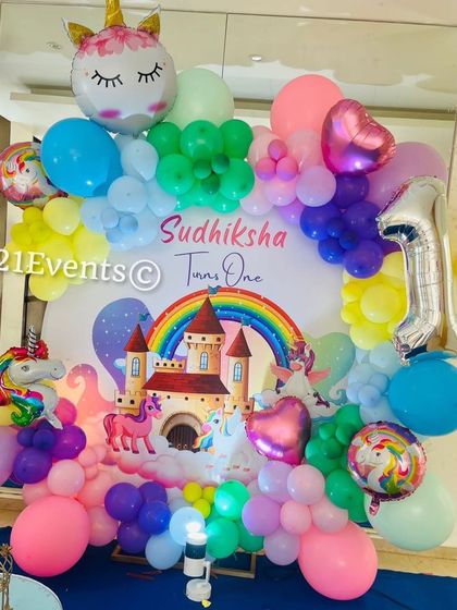 A magical unicorn theme with a castle backdrop and a rainbow of pastel balloons. The unicorn and heart-shaped foil balloons add an extra touch of whimsy.