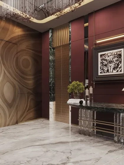 A dramatic entrance lobby visualization with deep red walls and a stunning, organically patterned feature door. The render captures the opulence of the crystal chandelier and marble console.