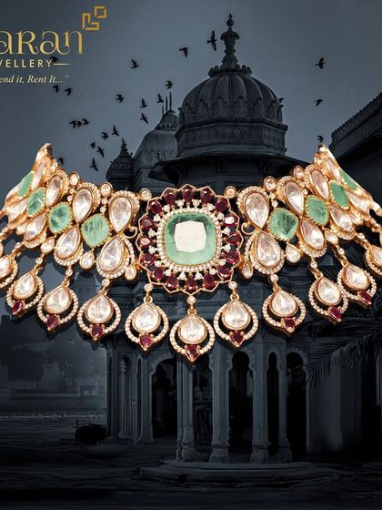 A breathtaking bridal choker featuring a large central emerald-cut stone, surrounded by Polki diamonds and ruby drops. A true masterpiece.