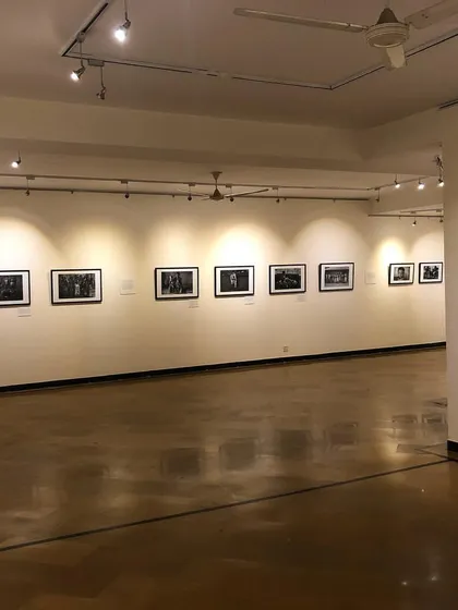 A long shot of the main gallery wall, displaying a series of photographs from the exhibition. This view demonstrates the scale and professional curation of our art shows.