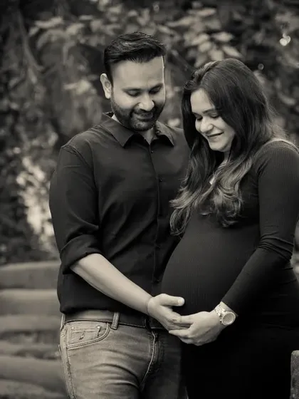 This black and white photo focuses on the couple's hands cradling the baby bump, a simple and powerful image of their shared love and anticipation.