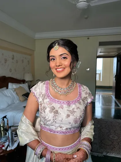 The client looking absolutely pretty with her rose bun and glowing makeup. This is a perfect look for attending a sister's or best friend's wedding.