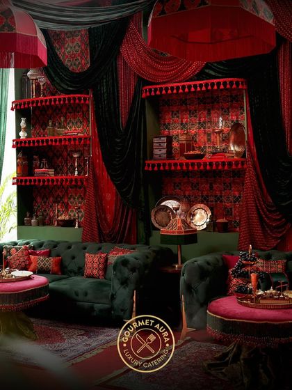A lavish lounge area with a rich red and green color scheme, showcasing how we can extend our design aesthetic beyond the dining area to create a complete event experience.