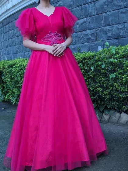 A vibrant pink gown with delicate butterfly sleeves and a beaded waist accent. This is a cheerful and elegant choice for a daytime party or event.