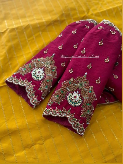 The heavy embroidery on these magenta sleeves is designed to look like traditional 'vanki' or armlets. The detail is packed with kemp stones and golden thread.