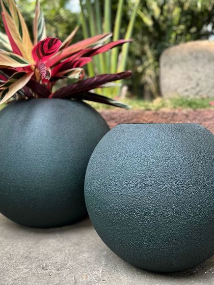 A pair of my 'Bola' planters in a dark, textured finish. They are chic, minimal, and perfect for a home office or cozy nook.