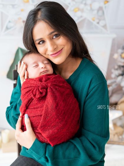 A mother and her newborn baby. This photo was part of a Christmas mini-session, capturing their first holiday season together.