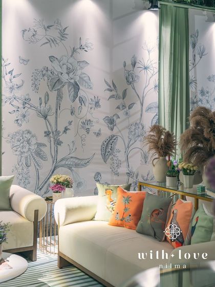 The lounge area in 'The Conservatory', with custom wallpaper and colorful cushions creating a chic and comfortable space.