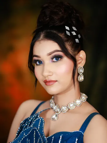 A close-up of the blue gown look, showing the intricate silver hair accessories and the perfectly blended smokey eye.