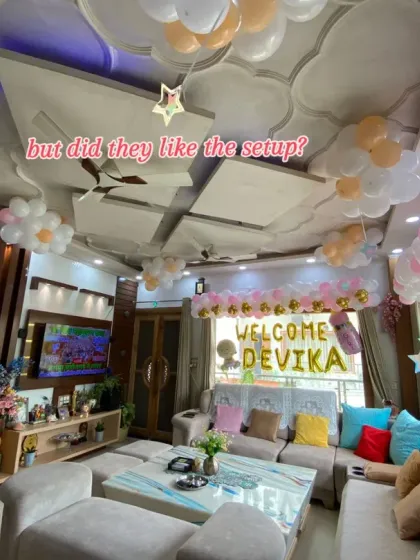 A wide-angle view of the welcome home decor for baby Devika. This shot shows how balloons were used not just for the main backdrop but also on the ceiling to fill the entire room with a festive and joyful feeling.