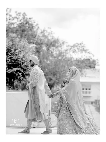 A timeless black and white shot of Ajay and Himanshi walking hand in hand. This classic composition emphasizes the beginning of their journey together as a married couple.