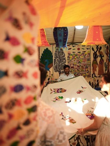 An artisan displays a beautifully embroidered textile to interested customers. This direct interaction is at the heart of what we do.