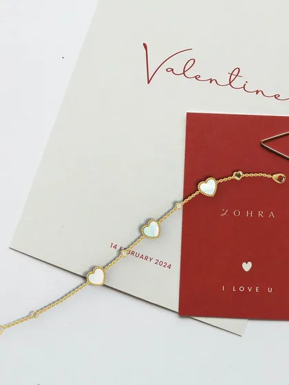 Love that speaks from the heart. This exquisite heart charm bracelet, featuring delicate mother of pearl accents, is the perfect way to celebrate your Valentine. It is a meaningful piece to cherish forever.