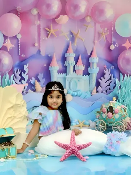 We bring fairy tales to life with our enchanting 'Little Mermaid' setup. This elaborate underwater scene features a castle, pastel balloons, and shimmering seashells, creating a magical world for your child's portrait.