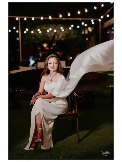 The bride's white gown features a dramatic, flowing sleeve, adding a touch of high fashion to this elegant dinner look.
