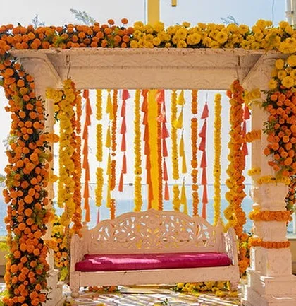 A classic white swing, beautifully decorated with marigolds, serves as the perfect photo spot for the Haldi ceremony.
