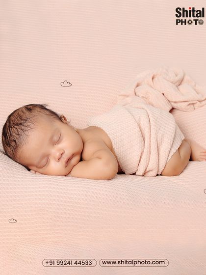 A classic tummy-time pose on a soft pink blanket. This position is a beautiful way to capture the baby's profile and the sweet rolls on their back.
