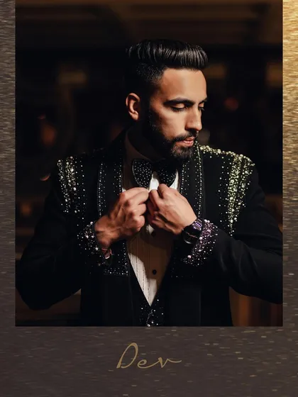 A classic portrait of the groom adjusting his bow tie. This shot captures the small, getting-ready details that add to the story of the day, highlighting his sharp, embellished tuxedo.