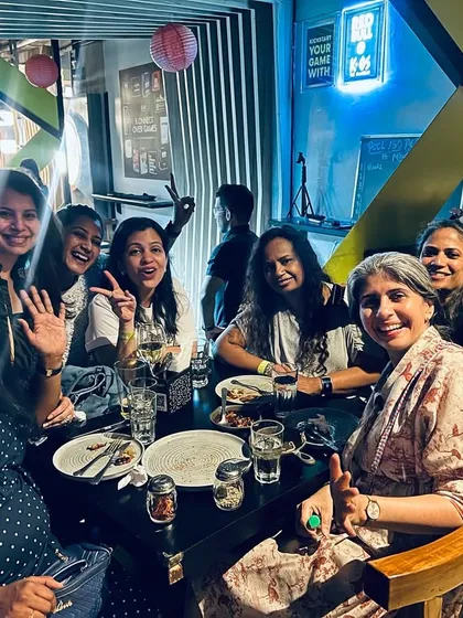 A table of friends from IIM Bangalore raising a toast to a phenomenal night of karaoke, games, and fun.