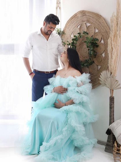 A look of love. This couple shares a sweet, connected moment in our bright and airy boho set, with the mom-to-be looking angelic in a ruffled blue gown.