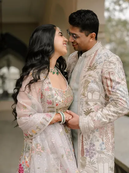 An intimate portrait capturing the loving gaze between the couple. The detailed embroidery on their outfits adds a layer of texture and elegance to the frame.