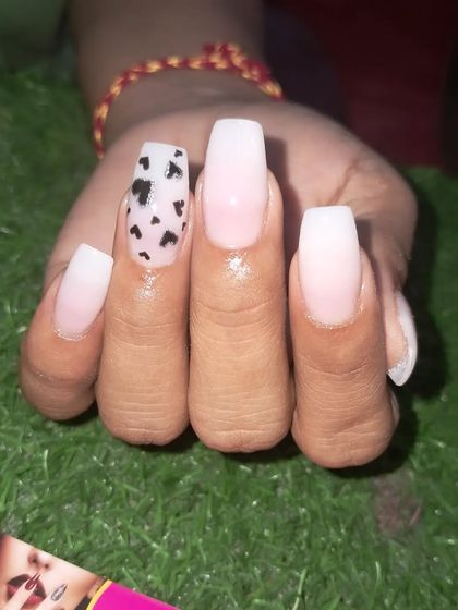 A close-up of the black hearts accent nail on this coffin-shaped set.