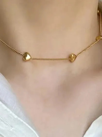 This delicate station necklace features small, puffy hearts spaced along a fine gold-tone chain. It's perfect for a subtle, romantic look.