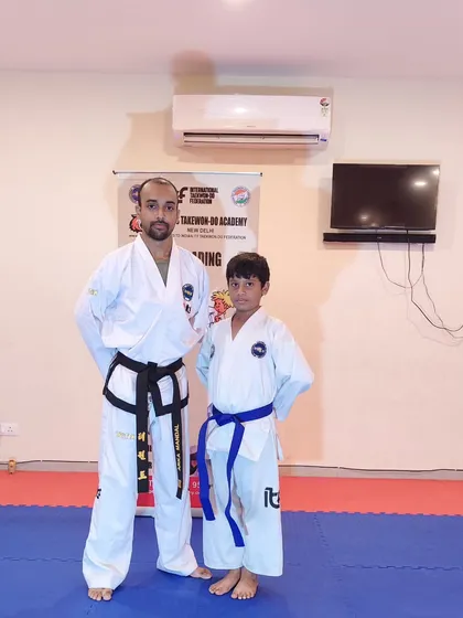 This young student has successfully been promoted to blue belt, a significant step in his training.